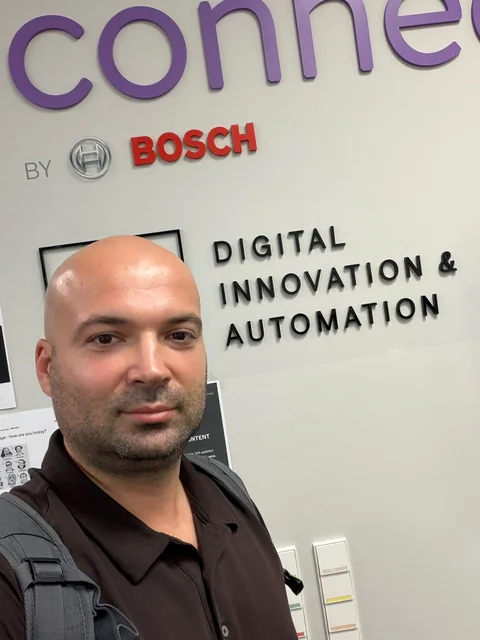 Liburn Shala vor dem Bosch-Schriftzug im Bereich Digital Innovation und Automation